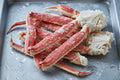 Frozen king crab legs on metal tray, premium seafood for home cooking